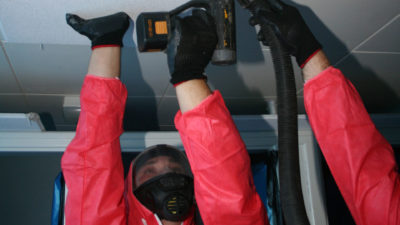 Workers checking roof during asbestos removal